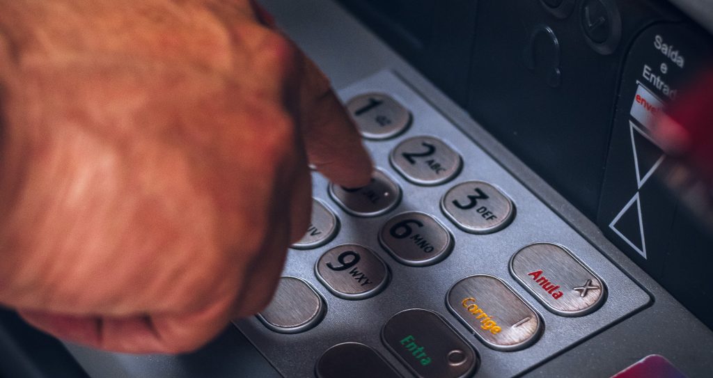 Man entering his PIN into an EMV certified payment terminal.