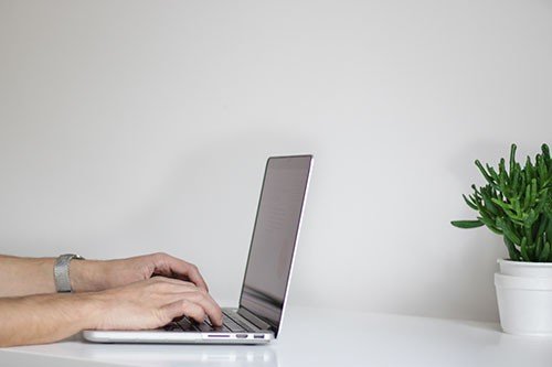 Mains Tapant sur un Clavier d’Ordinateur Portable Gris