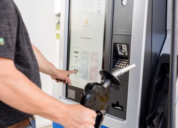 Client qui Interagit avec l’Écran de Paiement à la Pompe